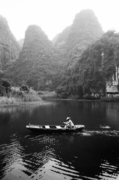 Film scan of a Vietnamese person rowing a canoe.