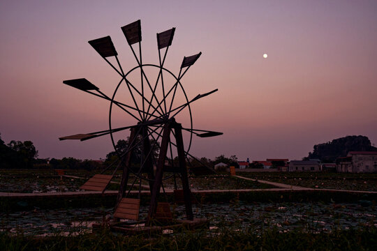 An old windmill in a rice paddy.