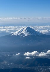 Majestic Mount Fuji View: A serene vista of Japan's iconic snow-capped volcano rising above the landscape, framed by fluffy clouds and a clear blue sky, offering a breathtaking panorama