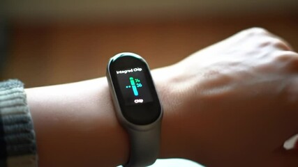 A close-up view captures a fitness tracker on a wrist, showcasing heart rate monitoring in real-time.