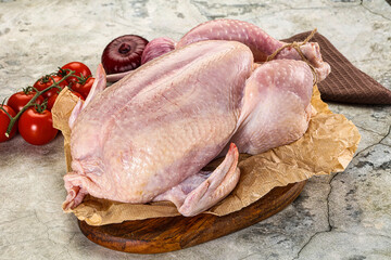 Fresh whole raw chicken over board