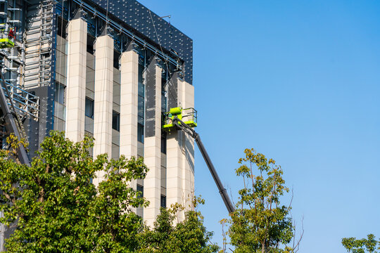 Construction Workers Installing Glass Windows on a Building