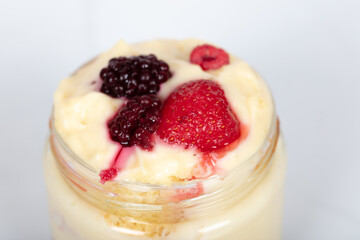 Delicious creamy dessert in glass jars topped with fresh strawberries, blackberries, and raspberries, perfect for sweet moments, homemade treats, and dessert lovers