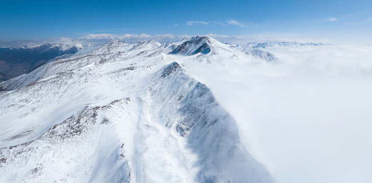 aerial landscape of snow mountain with mist under blue sky