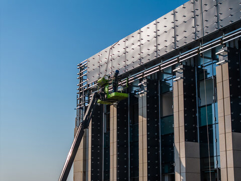 Construction Workers Installing Glass Windows on a Building