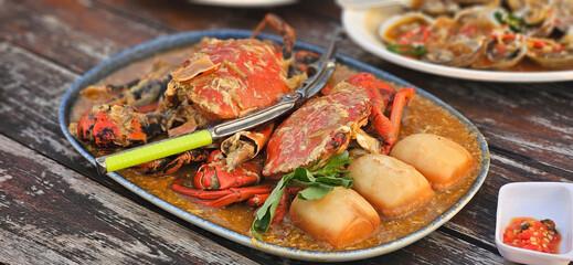 Chilli crab Singapore style serving with fried bun on the timber table
