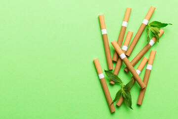 Menthol cigarettes and fresh mint leaves on colored background, Many cigarettes stacked together...