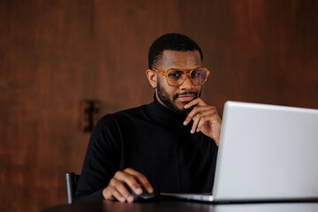 Focused man working on laptop in formal office