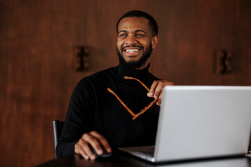 Smiling businessman working on laptop in elegant office