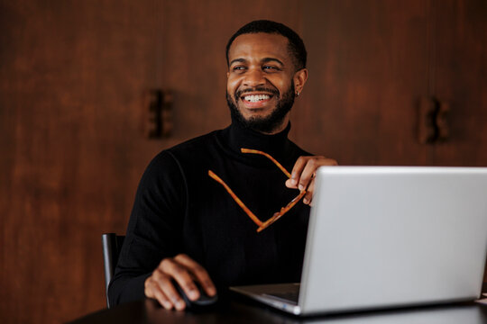 Smiling businessman working on laptop in elegant office