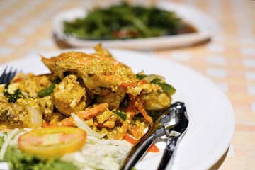 Thai dishes of stir-fried yellow curry crab and morning glory (Kang Kong) on a table with gingham tablecloth at Cliff Restaurant, Patok Bay - Ko Racha Yai, Thailand