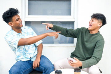 Obraz premium Two men at cafe talking and laughing, enjoying their time together