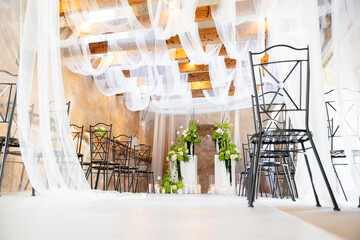 Elegant wedding ceremony venue decorated with white cloth and flowers