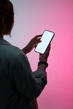 A woman's hand interacts with a blank smartphone screen set