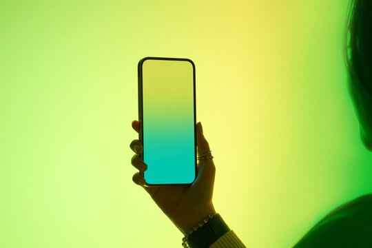 A Woman holds a mobile phone with a gradient screen