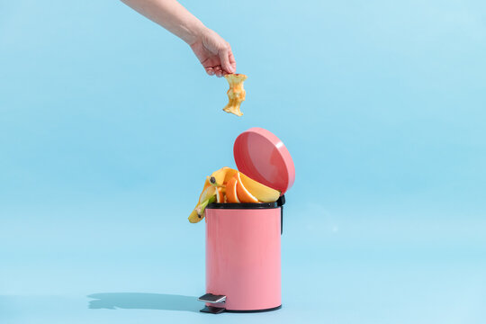 Food waste disposal, composting. Trash can on blue