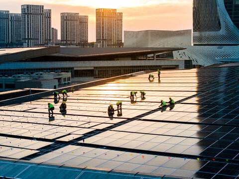 Aerial View of City Rooftop with Solar Panels and Workers