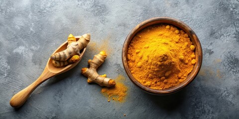 Turmeric powder in a wooden bowl with dried turmeric root on grey background top view , spice, dried turmeric root