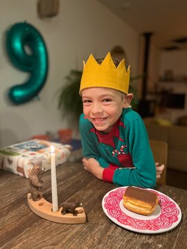 happy boy celebrating his 9th birthday with cake