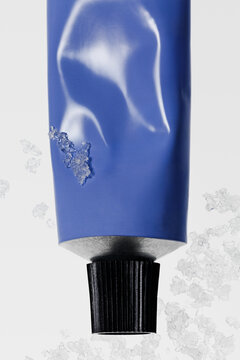 Close-up of blue tube of cream with snow