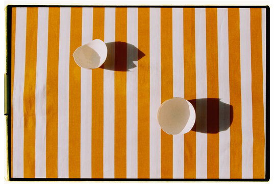 Two empty shells on a striped orange and white tablecloth