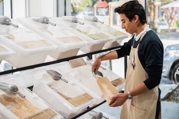 Worker Filling Bags with Grains in Bulk at Zero-Waste Store
