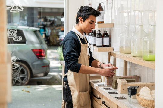Young Retail Worker Organizes Eco-Friendly Soap Display