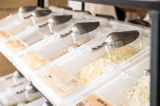 Bulk food storage bins with metal scoops in a grocery store
