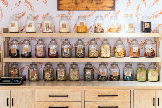 Glass jars with spices on kitchen shelf in rustic decor