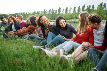 Young diverse community enjoying time together in nature outdoors - multicultural casual students...