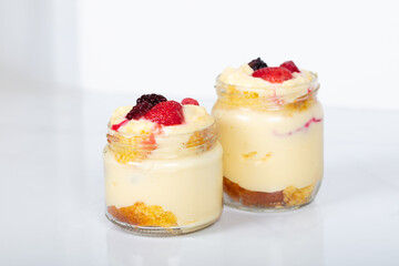 Delicious creamy dessert in glass jars topped with fresh strawberries, blackberries, and raspberries, perfect for sweet moments, homemade treats, and dessert lovers