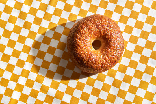 Fresh bagel for breakfast on checkered tablecloth with copy space