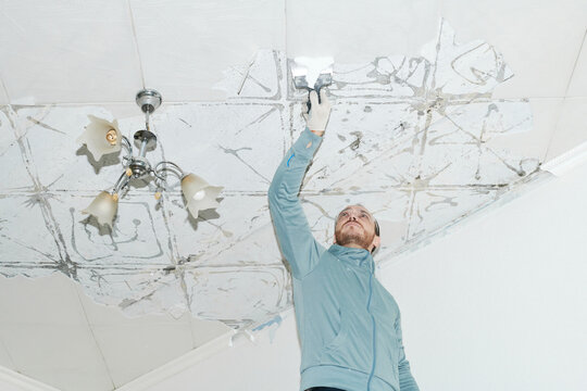 Man repairing ceiling in home renovation project