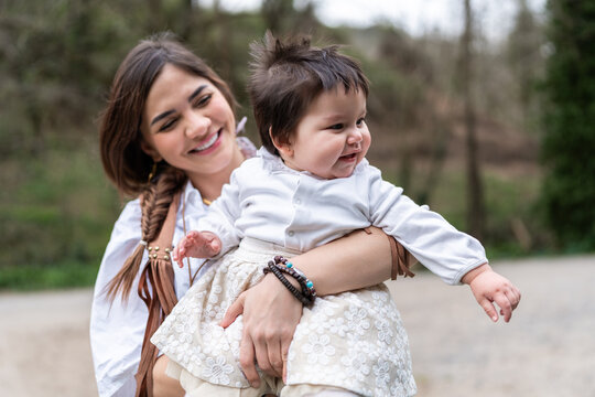 Venezuelan mother holding her baby girl in a park