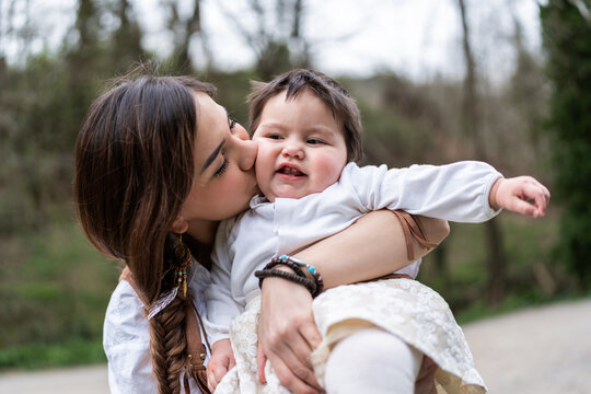 Young Venezuelan Mother Kissing her Baby Daughter in a Park