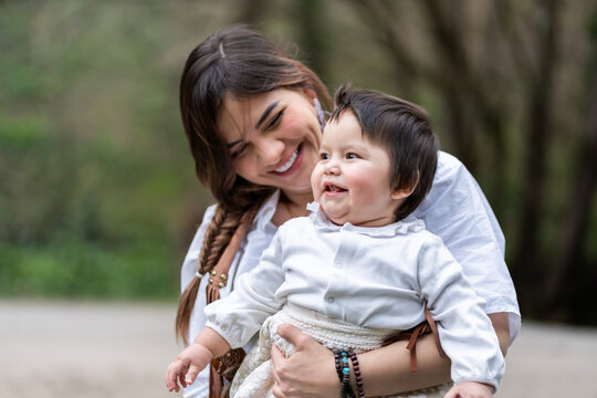 Venezuelan mother holding her smiling baby