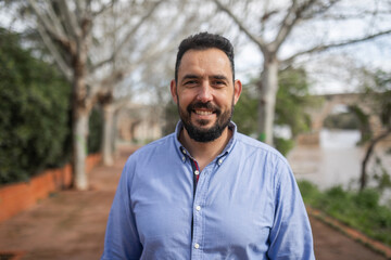 Portrait of a bearded young man on a city promenade
