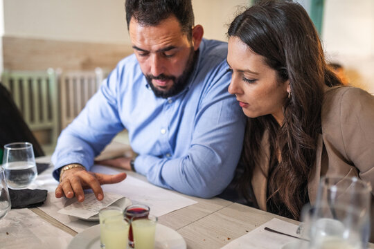 couple in restaurant looking at the ticket to pay