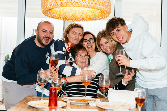 Happy family celebrating with grandma and their dog at home