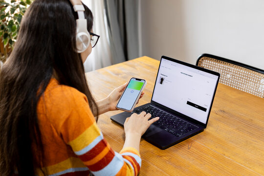 Woman at home shopping online paying with smartphone pay app