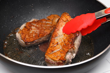 Smażony na patelni na złocisty kolor filet z piersi kaczki przekręcany na drugą stronę,  © Paweł Kacperek