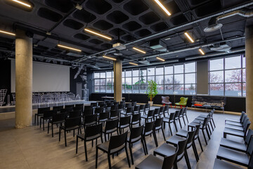 Modern conference room with rows of black chairs