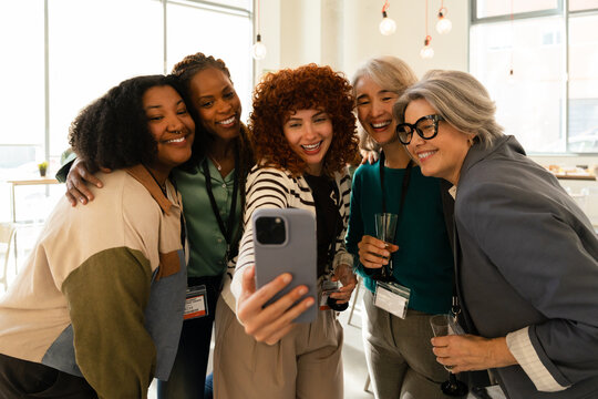 Group of diverse women taking a selfie at the office - Powered by Adobe