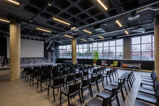 Modern conference room with rows of black chairs