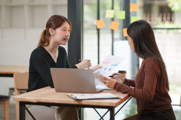 Obraz premium Group of Asian businesswomen working on documents in an office.