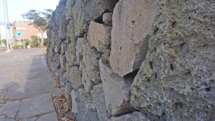A high-quality stock image showcasing a close-up view of an aged dry stone wall with irregular rocks and moss-covered surfaces, ideal for historical and rustic themes.