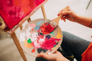 Vibrant paint palette with wide brush during canvas painting pro