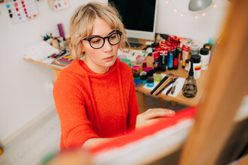 Focused female painter working on colorful canvas