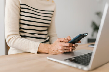 Naklejka premium Close-up view of woman hands using mobile phone device at office workplace. Technology lifestyle and business concept.