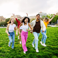 Group of young student friends having fun running together outdoors. Friendship lifestyle concept